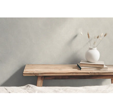 Scen med en strukturerad tapet, en träbänk, böcker och en vas med växter