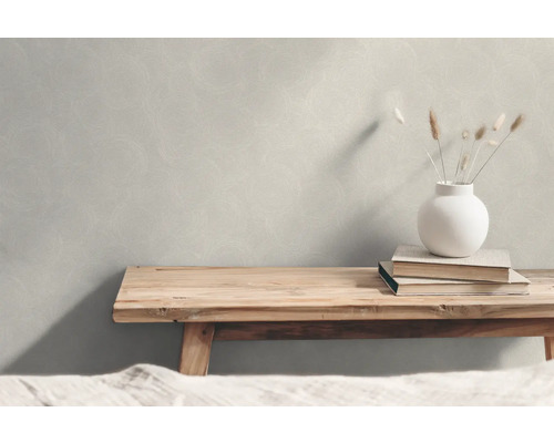 Scen med en strukturerad tapet, en träbänk, böcker och en vas med växter