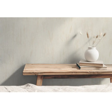 Dekorativ scen med träbänk, böcker och en vas med torkade blommor.