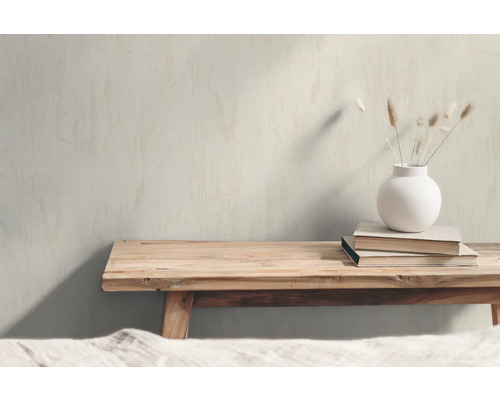 Dekorativ scen med träbänk, böcker och en vas med torkade blommor.