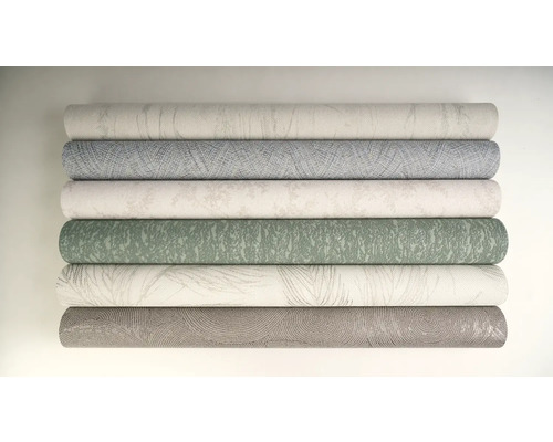 Stapel med olika rullar av mönstrade tapeter