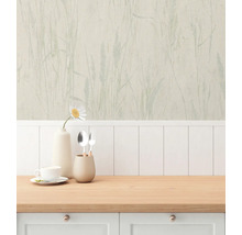 Köksscen med tapet med växtmönster, porslin och träbänkskiva.