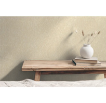 Vägg med non-woven tapet, böcker och blomvas på ett träbord