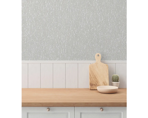 Köksscen med mönstrad tapet, skärbräda, skål och kaktus på en arbetsbänk