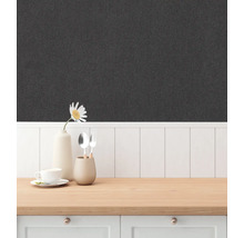 Närbild av en strukturerad, mörk tapet inomhus