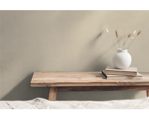 Dekorativt arrangemang med träbänk, böcker och vas med prydnadsgräs