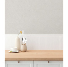 En scen av en köksbänk med diskar och en vas mot en bakgrund av mönstrad tapet