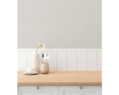 En scen av en köksbänk med diskar och en vas mot en bakgrund av mönstrad tapet