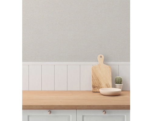 Dekorativ köksscen med skärbräda, skål och kaktus på en bänkskiva framför en texturerad tapet