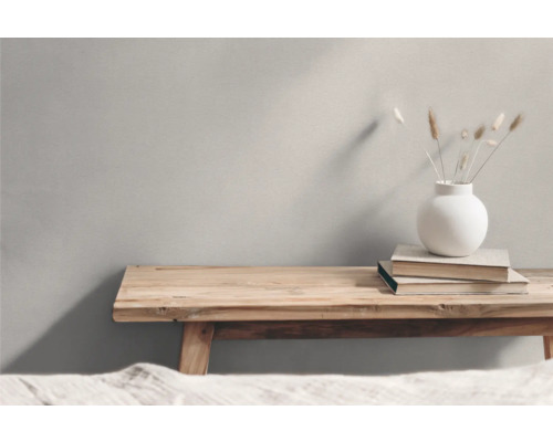 Träbänk med böcker och en vas med torkade blommor som dekoration