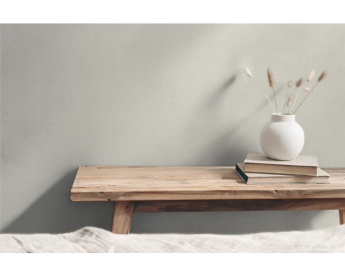 Dekorativt arrangemang med träbänkar, böcker och en blomstervas