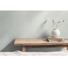 Dekorativ scen med en träbänk, böcker och en vas med prydnadsgräs