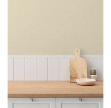 Köksscen med skärbräda, skål och kaktus på en bänkskiva framför en panelvägg.