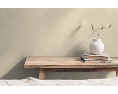 Träbänk med böcker och en vas med torkade blommor