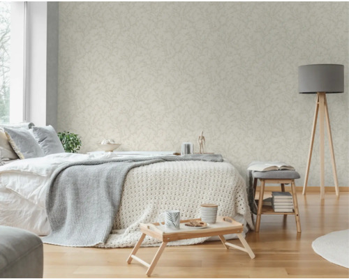 Ljust sovrum med mönstrad tapet, säng, lampa och sidobord