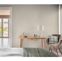 Ljust rum med skrivbord, stol och dekorativa element för en mysig atmosfär.