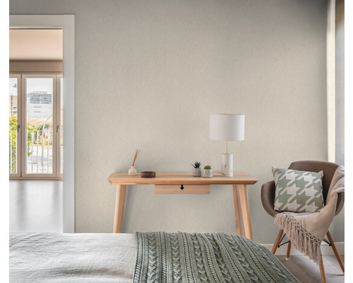 Ljust rum med skrivbord, stol och dekorativa element för en mysig atmosfär.