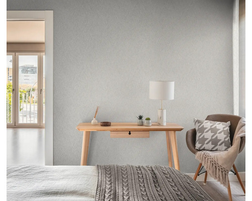 Sovrum med mönstrad tapet, skrivbord, stol och säng