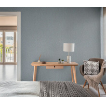 Scen av ett sovrum med ett träbord, en lampa och en strukturerad tapet