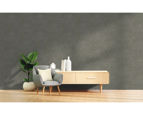 Vardagsrum med grå strukturvägg, fåtölj, växt och byrå