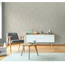 Vardagsrum med fåtölj, soffbord och mönstrad tapet