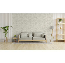 Vardagsrum med soffa, golvlampa, hylla och tapet med bladmönster.