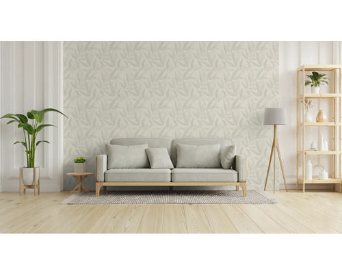 Vardagsrum med soffa, golvlampa, hylla och tapet med bladmönster.