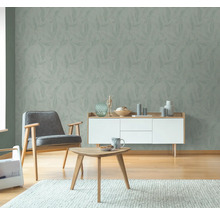 Vardagsrum med blommönstrad tapet, fåtölj, skänk och soffbord