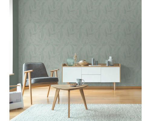 Vardagsrum med blommönstrad tapet, fåtölj, skänk och soffbord