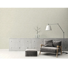 Vardagsrum med fåtölj, golvlampa och betongkonsol