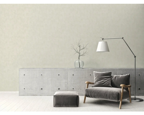 Vardagsrum med fåtölj, golvlampa och betongkonsol