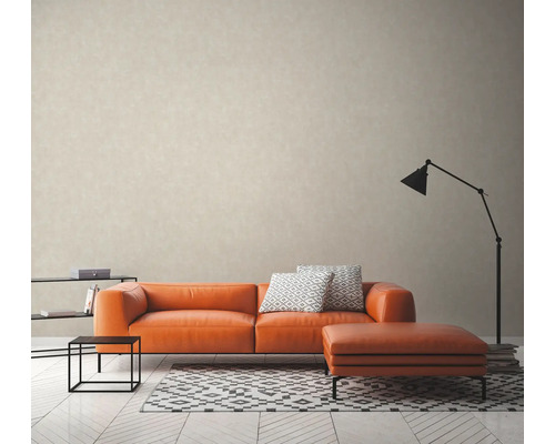 Vardagsrum med orange soffa, pall, lampa och matta på ljust trägolv