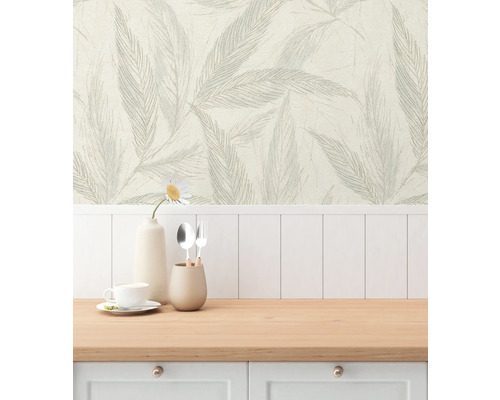 Scen med en tapet med bladmönster bakom en köksbänk.