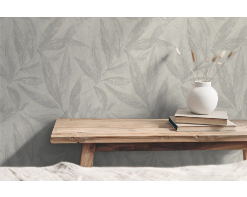 Scen med mönstrad tapet, träbord, böcker och vas