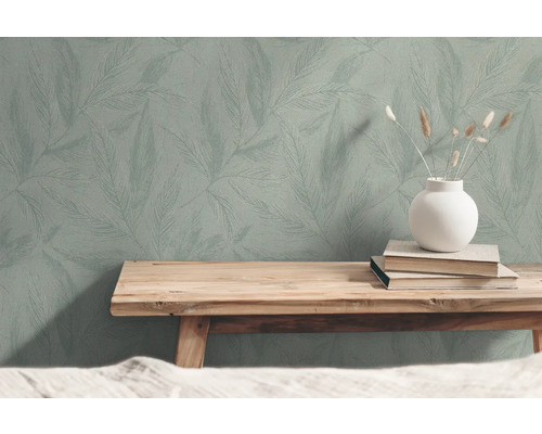 Tapet med bladmönster, böcker och vas på träbänk