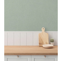 Ljust kök med mönstrad tapet, arbetsbänk i trä, skärbräda och kaktus