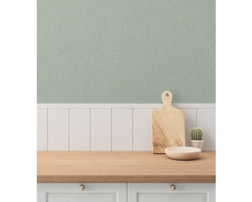 Ljust kök med mönstrad tapet, arbetsbänk i trä, skärbräda och kaktus