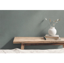 Dekorativt arrangemang med träpall, böcker och vas med prydnadsgräs