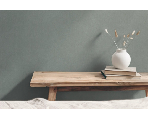 Dekorativt arrangemang med träpall, böcker och vas med prydnadsgräs