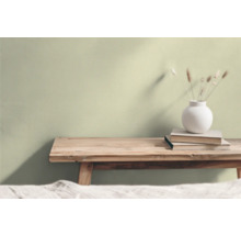 Vardagsrum med träpall, bokhög och blomvas