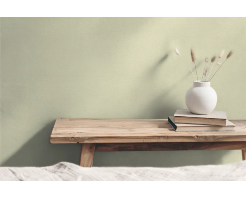 Vardagsrum med träpall, bokhög och blomvas