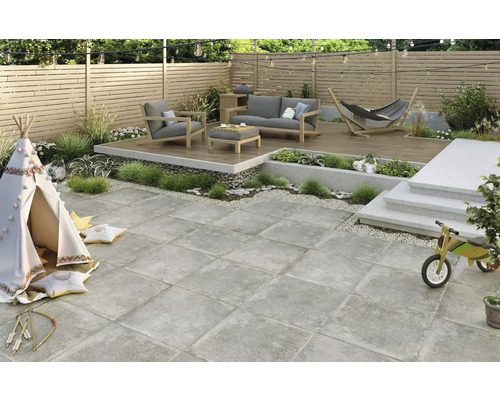 Terrass med möbler, lekplats och kvadratiska gatstenar