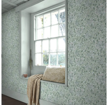 Ljust rum med fönsterbräda, kudde, filt och blommig tapet