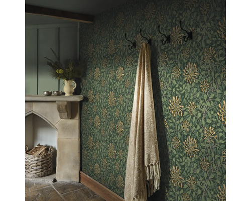 Mysigt rum med blommig tapet, öppen spis och filt på hängaren