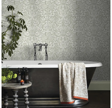 Badrum med mönstrad tapet, badkar och dekoration