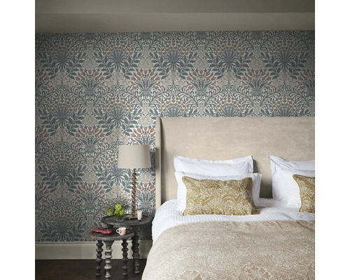 Sovrum med blommönstrad tapet, säng och sängbord