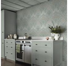 Köksscen med blommönstrad tapet, spis och grå skåp