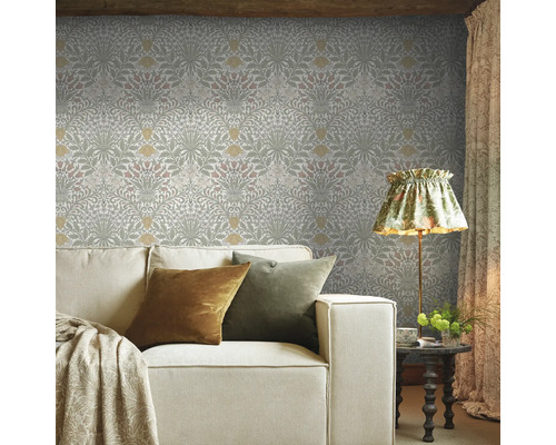 Vardagsrum med blommig tapet, soffa, lampa och sidobord