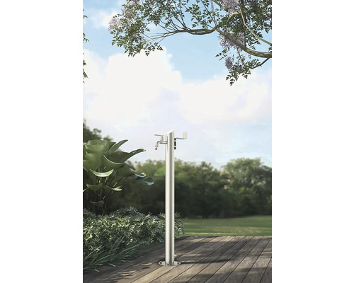 Trädgårdsscen med fristående metallvattenpelare på en träterrass