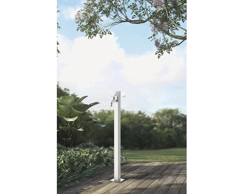 Trädgårdsscen med en enda metallvattenkran på en träterrass